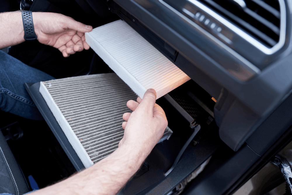 Cabin air filter replacement, auto repair in Piedmont, SC by Palmetto Complete Auto Care. Image of a technician installing a new clean cabin air filter behind the glove box to improve interior air quality and HVAC system performance.